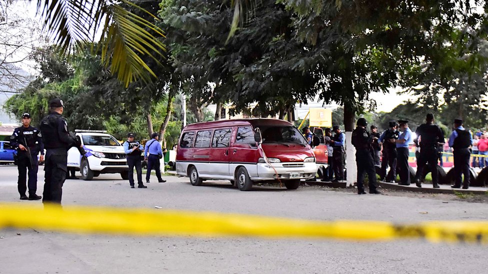 Члены полиции Гондураса охраняют автомобиль, предположительно использованный в перестрелке