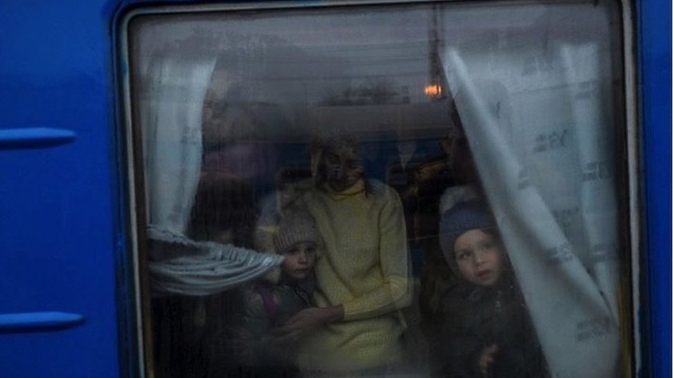 Children and their mother peering out of a train window