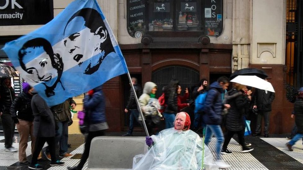 Una mujer ondea bandera con los rostros de Juan Domingo Perón y Evita durante una marcha a favor del aumento del sueldo de los maestros y en contra de los recortes a las universidades públicas de Argentina, en Buenos Aires, el 30 de agosto de 2018.