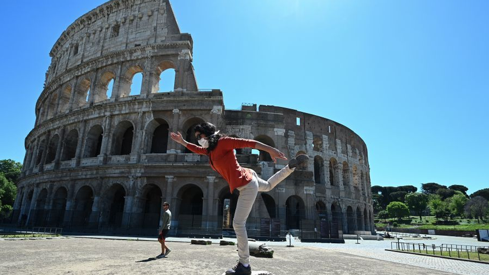 Mulher fazendo exercícios em frente ao Coliseu de Roma
