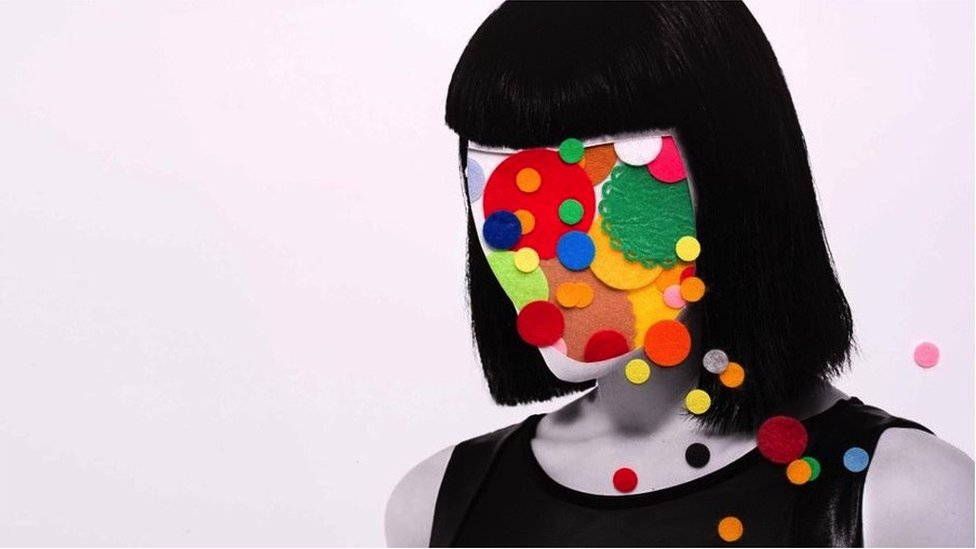 A woman in black and white with colours all over her face