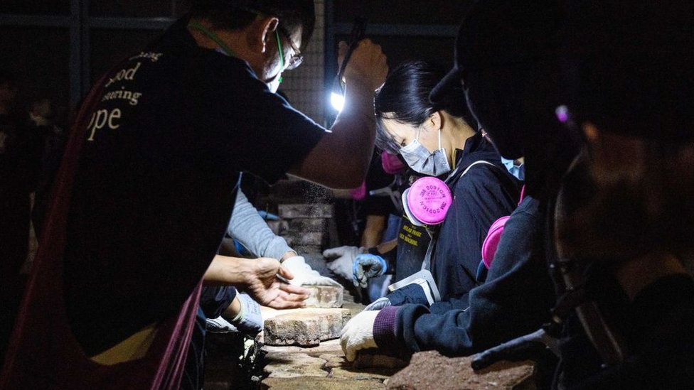 Manifestantes levantando un muro de ladrillos. Manifestantes levantando un muro de ladrillos.