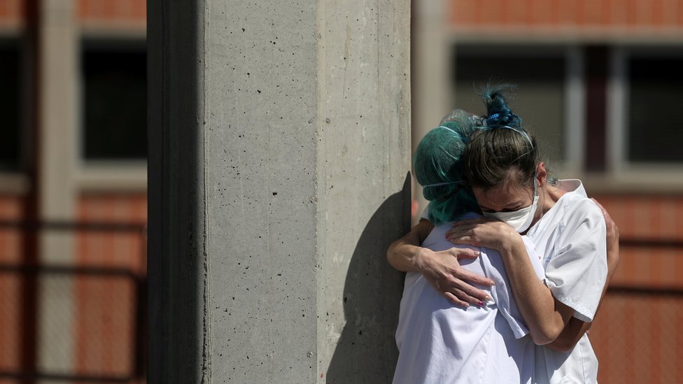 Медицинские работники обнимают друг друга перед отделениями неотложной помощи больницы Северо-Очоа во время коронавирусной болезни в Испании