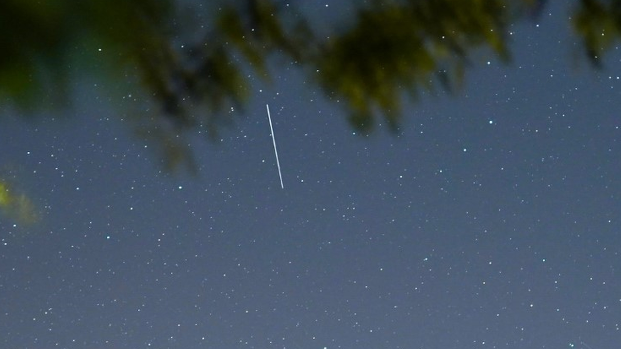 A Starlink satellite appears as a streak of light in the evening sky.