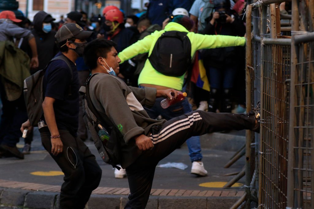 Un manifestante patea una valla en Quito, Ecuador.