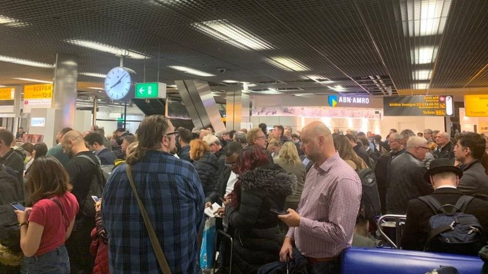 Пассажиры стоят в аэропорту Схипхол в Амстердаме во время предупреждения службы безопасности