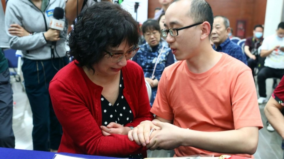 Li Jingzhi se toma de las manos con su hijo.