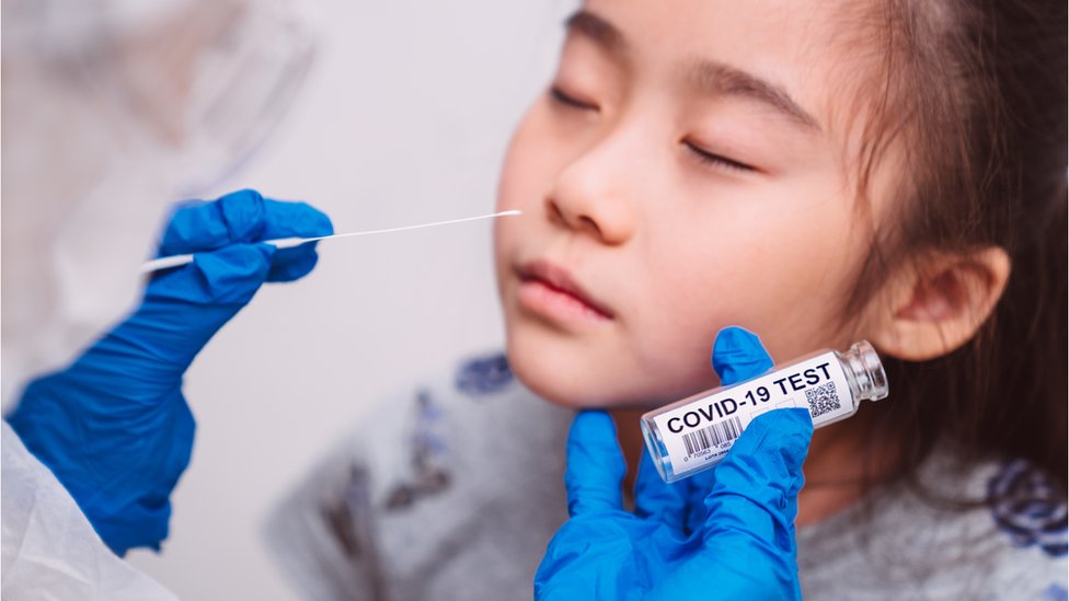 Médico faz swab nasal em menina asiática