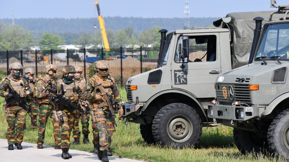 Soldados fuertemente armados participan en un barrido intensivo de un área en el borde del Parque Nacional Hoge Kempen en Maasmechelen el 4 de junio de 2021, en busca de Jürgen Conings.