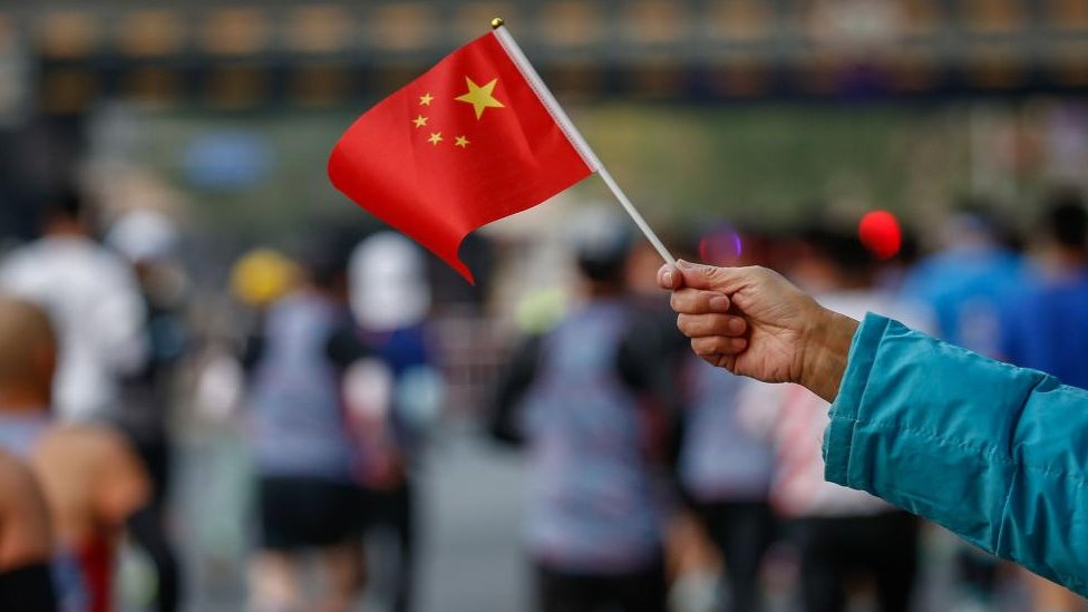 Uma bandeira nacional chinesa é hasteada em um evento em Pequim