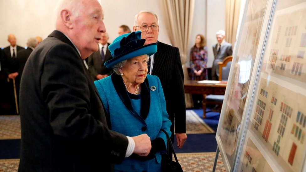 Kraljica Elizabeta Druga dok je pokazuju marke prethodnih britanskih monarha tokom posete novog sedišta Kraljevskog filatelističkog društva