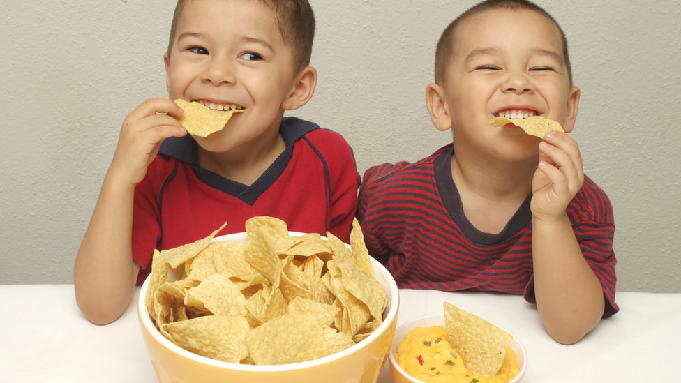 طفلان يأكلان شرائح بطاطس