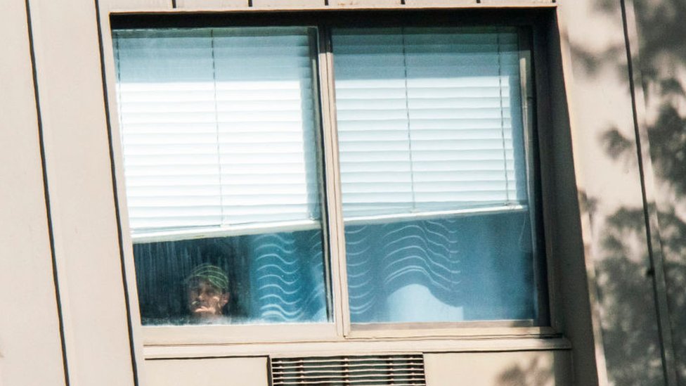 Мужчина смотрит в окно учреждения