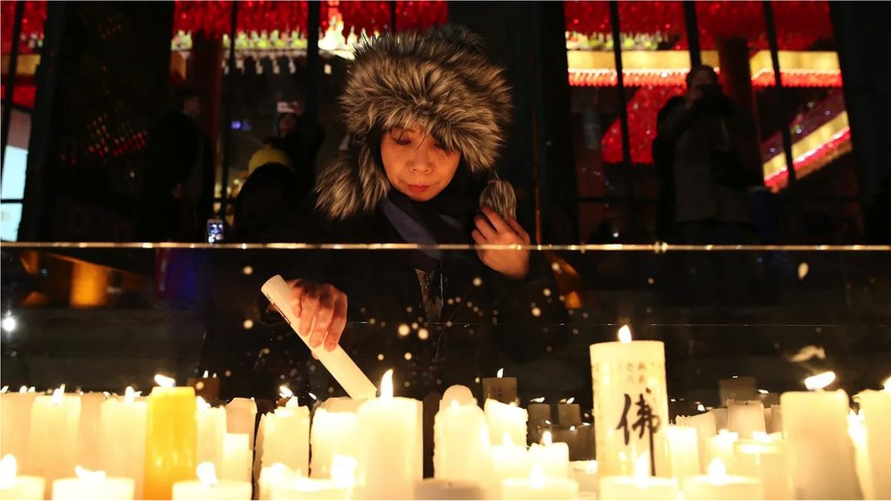 A South Korean woman lights up a candle during New Year celebrations