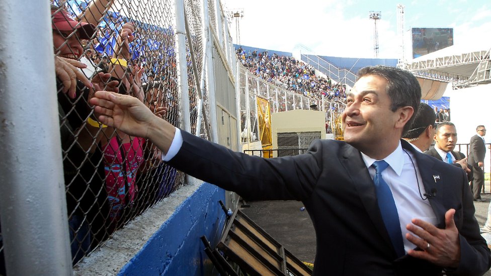 Переизбранный президент Хуан Орландо Эрнандес машет толпе по прибытии на церемонию инаугурации на национальном стадионе Tiburcio Carias Andino в Тегусигальпе 27 января