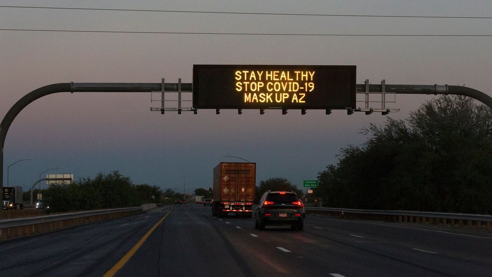 Знак автострады гласит: «Будьте здоровы, остановите Covid-19, замаскируйте АЗ»