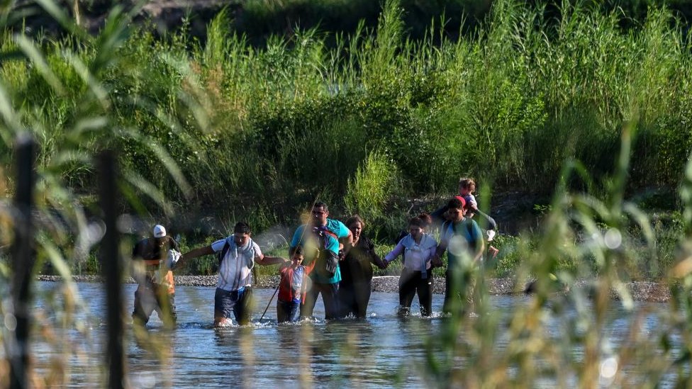 Una familia de Venezuela cruza ilegalmente el Río Grande en Eagle Pass, Texas, en la frontera con México el 30 de junio de 2022.