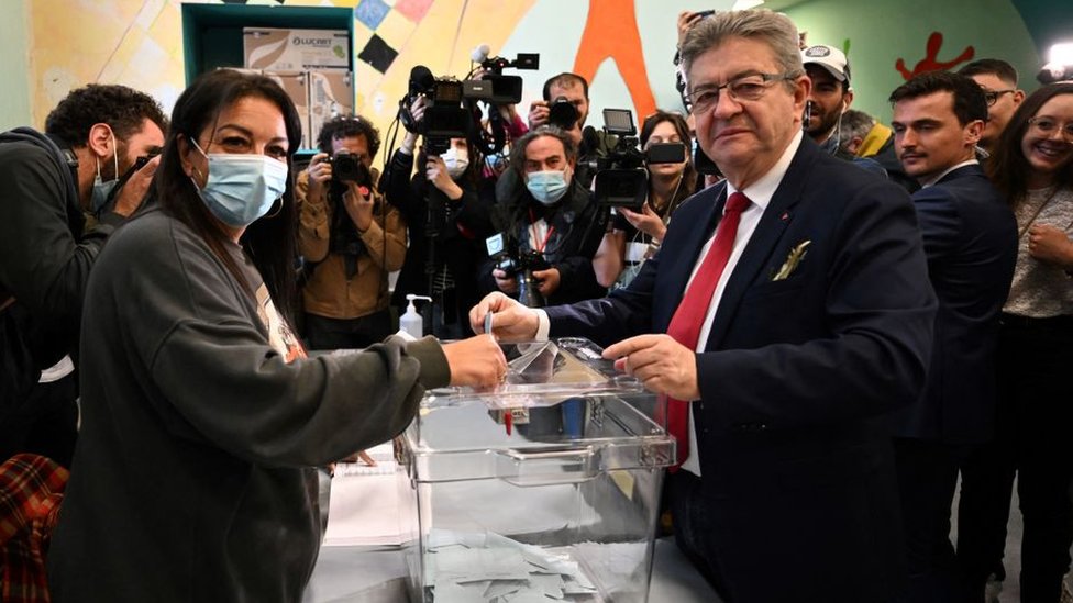 French leftist party La France Insoumise (LFI) presidential candidate Jean-Luc Melenchon (R) casts his ballot for the first round of France's presidential election at a polling station in Marseille, southern France on April 10, 2022