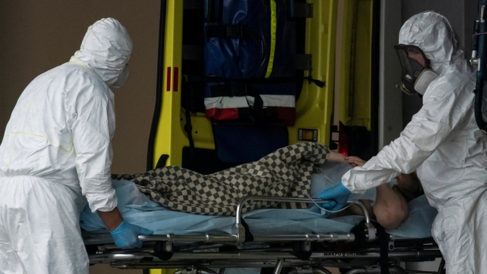 12 мая врачи вывозят человека на носилках возле больницы на окраине Москвы