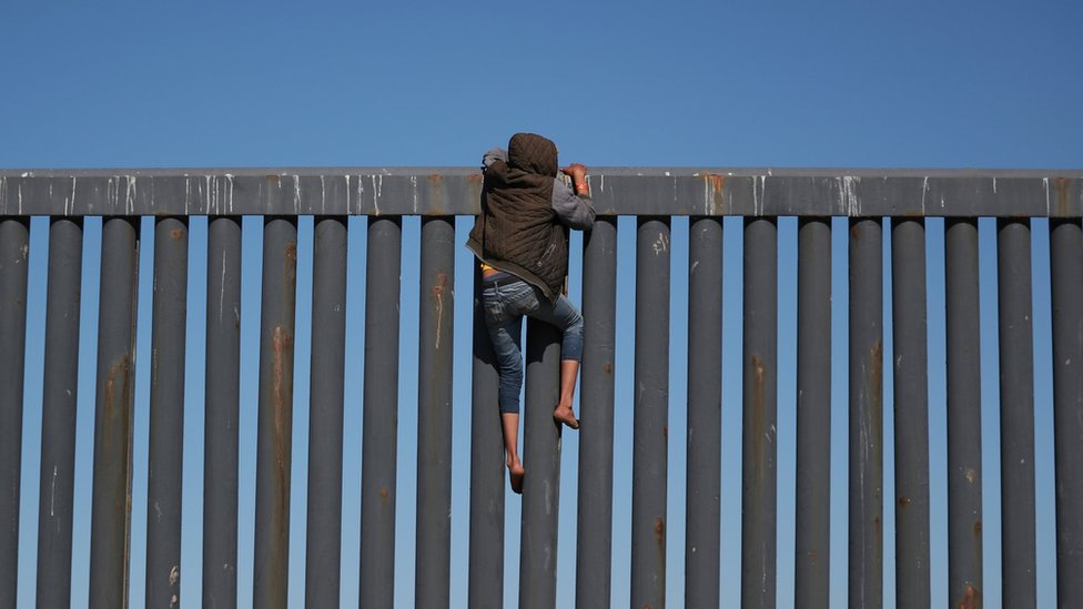 Migrant pokušava da preko ograde uđe u SAD