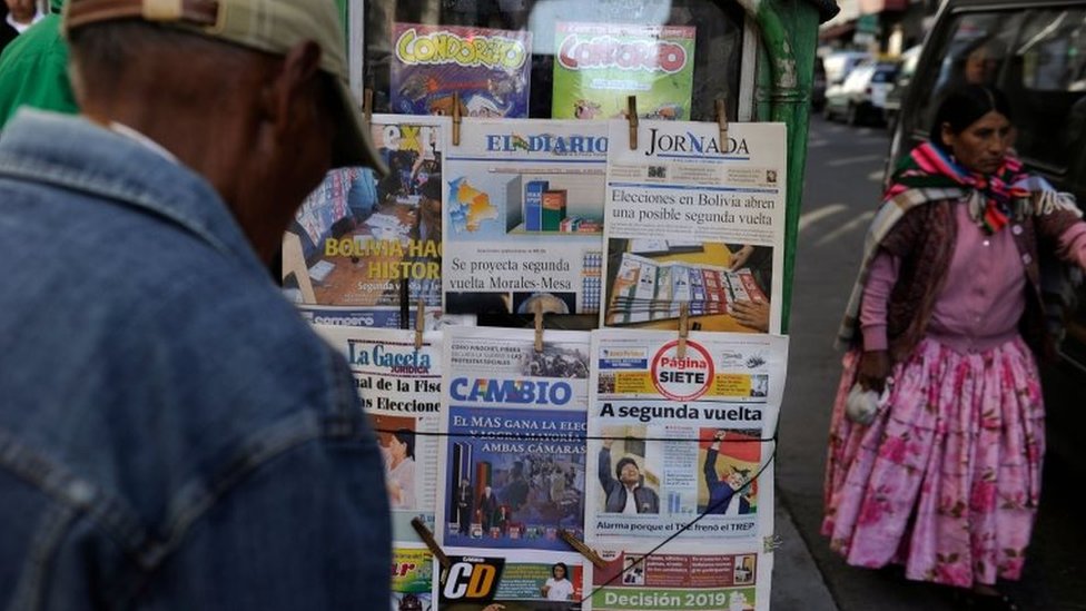 Люди читают первые полосы газет после президентских выборов в Ла-Пасе, Боливия, 21 октября 201 г.