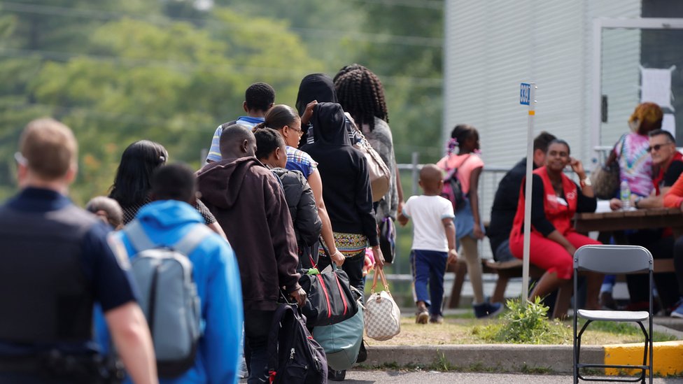 Лица, ищущие убежища, ожидают обработки на пересечении Квебек-Нью-Йорк