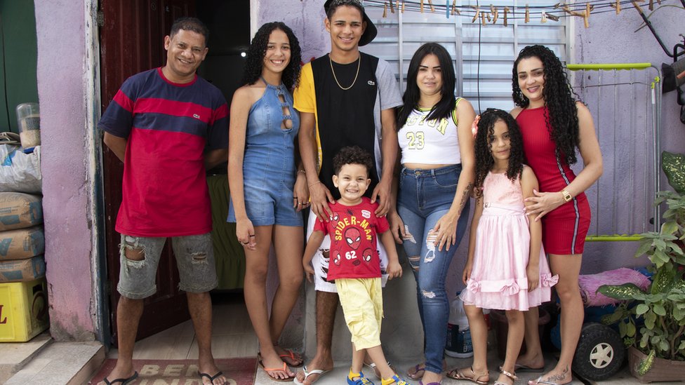 Robenilton Rosa dos Santos e sua família, em frente à casa onde moram na Favela do Moinho
