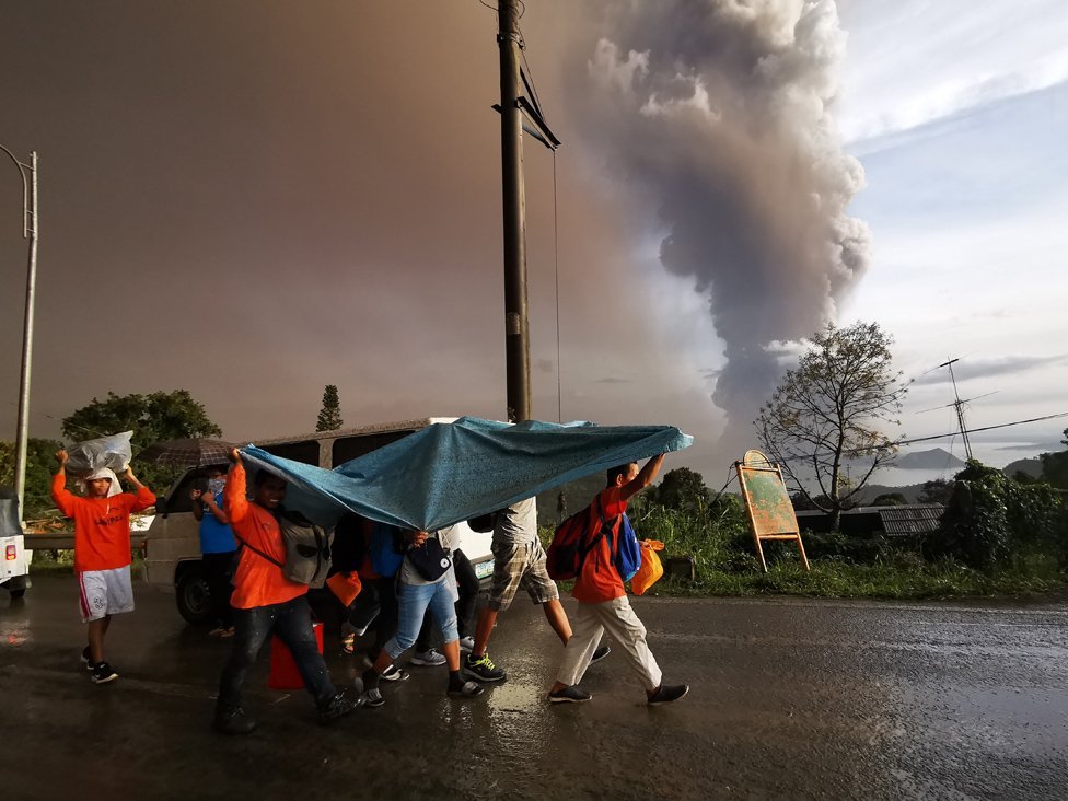 Столб пепла от извержения вулкана Таал нависает над городом Тагайтай, Филиппины, 12 января