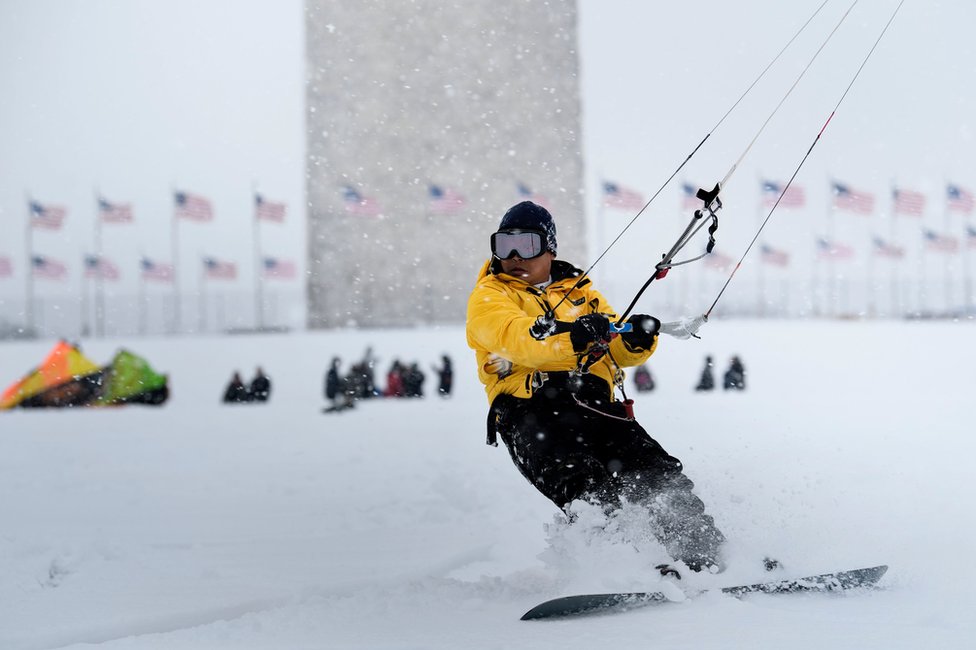 A man kite surfs in the snow