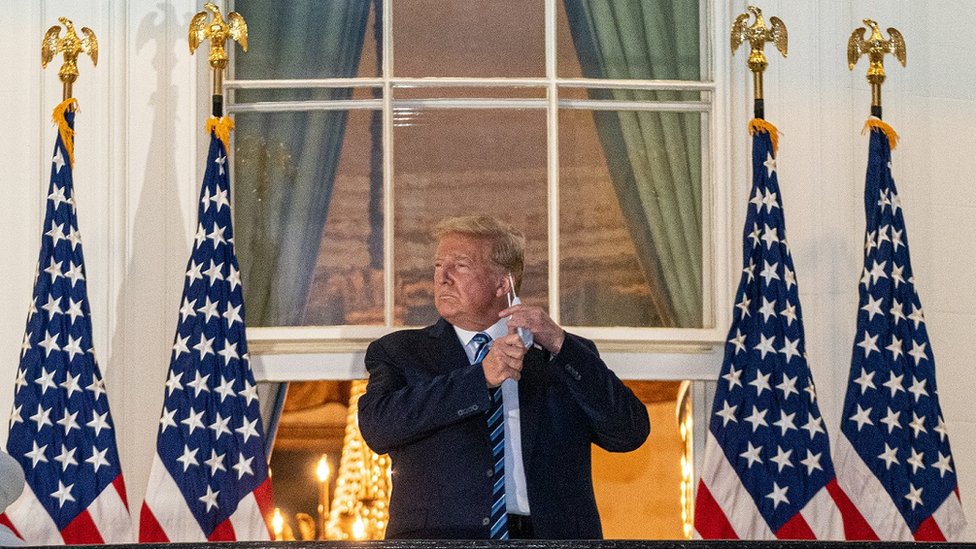 Trump en el balcón de la Casa Blanca quitándose el tapabocas