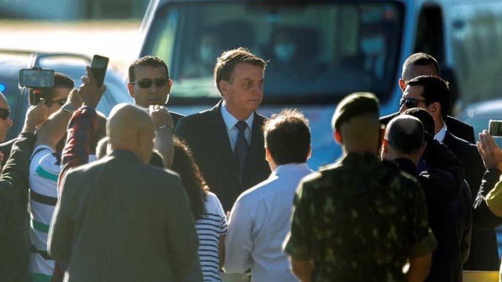 Президент Бразилии Жаир Болсонару (в центре) покидает Паласио-ду-Альворада, штаб-квартиру президентства, в Бразилиа, Бразилия, 15 июня 2020 г.
