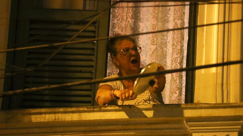 Женщина в Рио-де-Жанейро бьет кастрюлю и сковородку во время выступления Жаира Болсонару