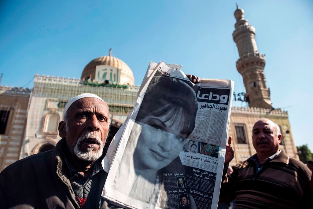 رجلان مصريان يحمل أحدهما صحيفة بها صورة لشادية وعنوان يقول " وداعا معبودة الجماهير.
