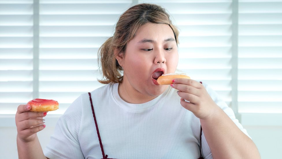 Mujer comiendo donuts