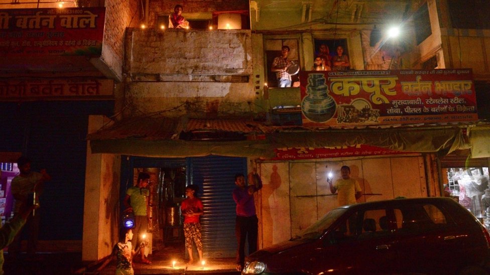 Жители Индии зажигают свечи и зажигают свои мобильные телефоны