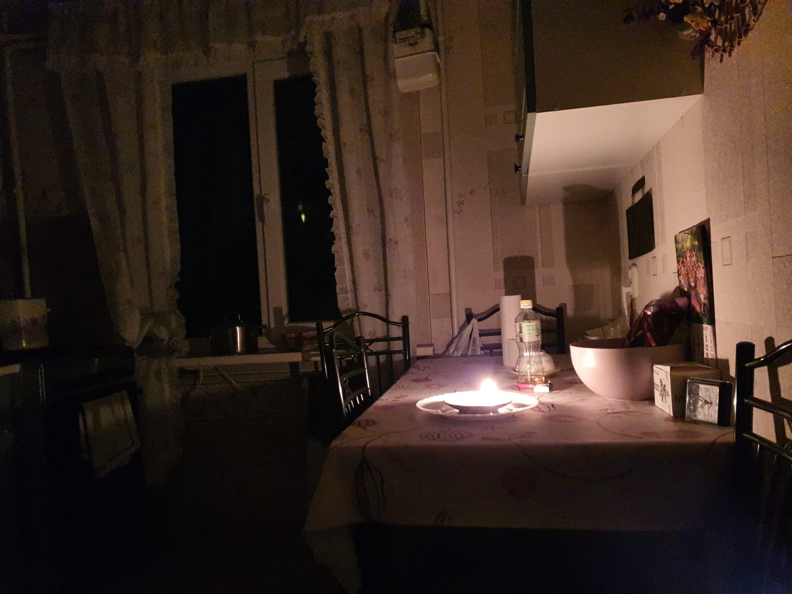 Casa com uma vela acesa em meio à escuridão
