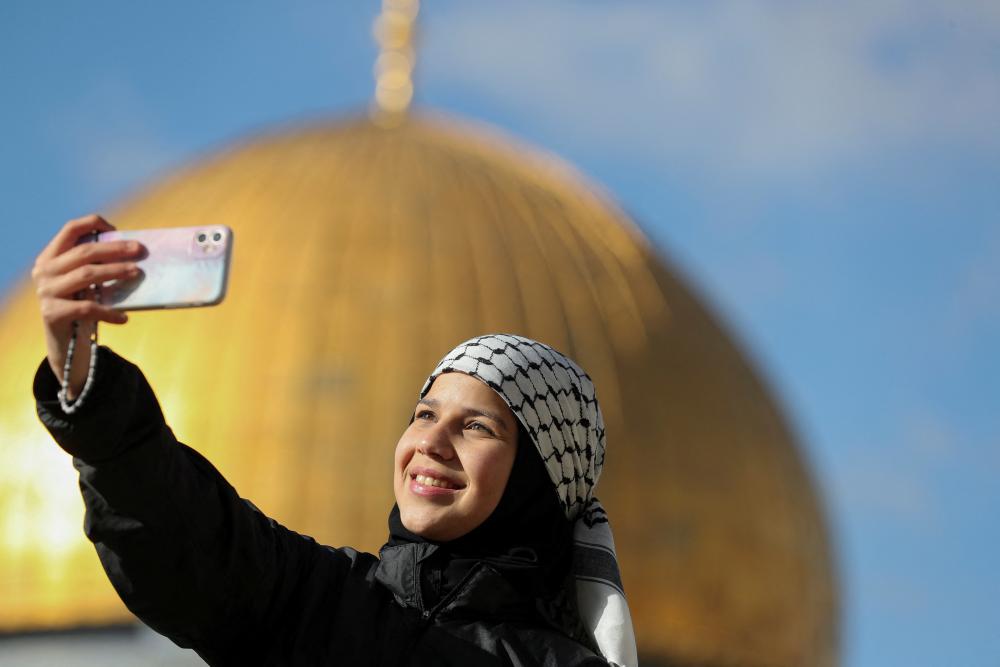 امرأة فلسطينية تلتقط صورة سيلفي