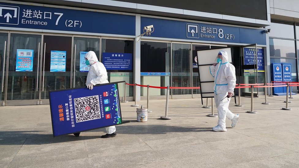 青海西寧火車站工作人員撤除掃碼提示牌（中新社圖片/12/2022）