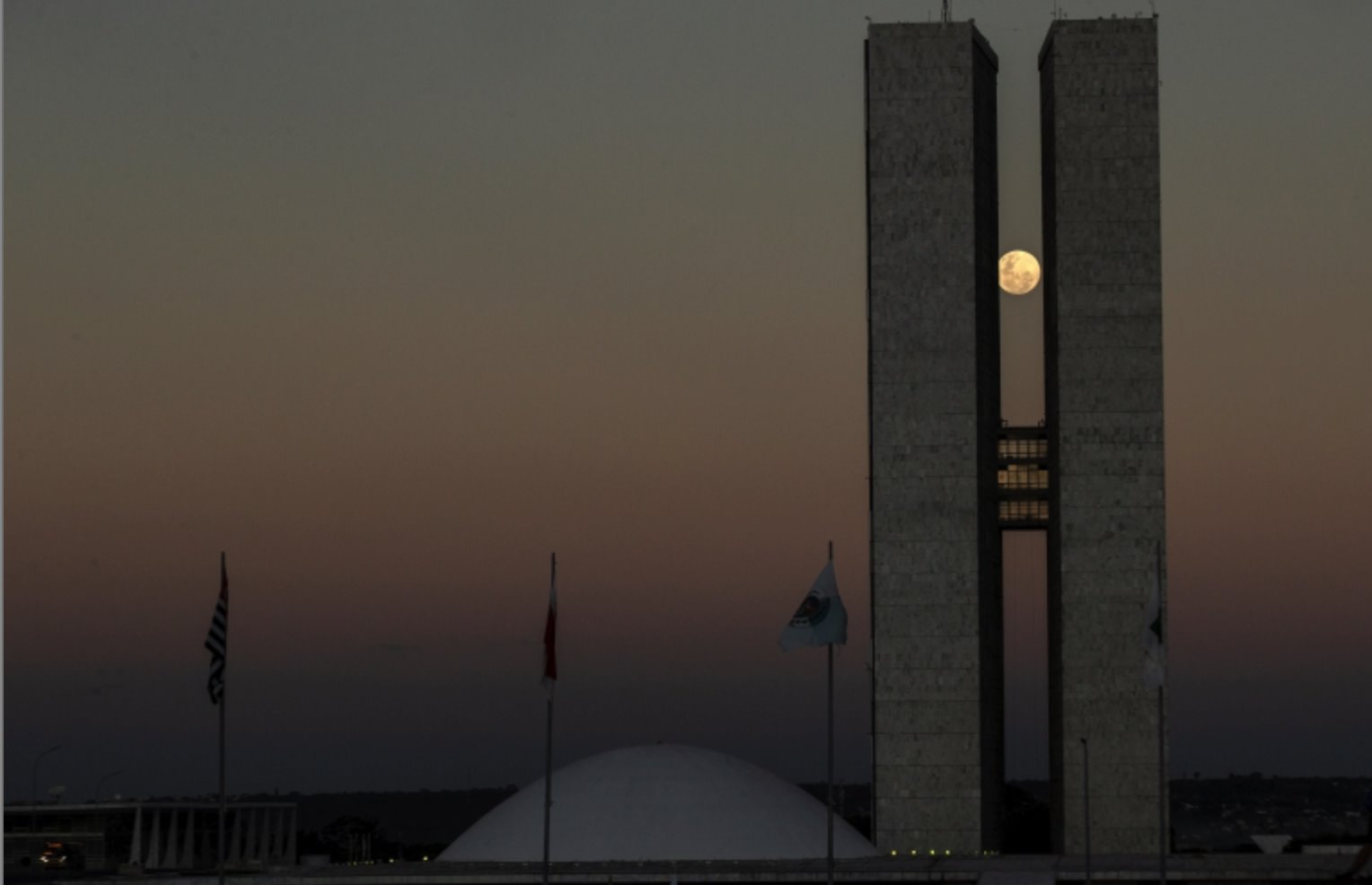 Vista da lua cheia entre as duas torres do prédio do Congresso Nacional, em Brasília, na noite do dia 25