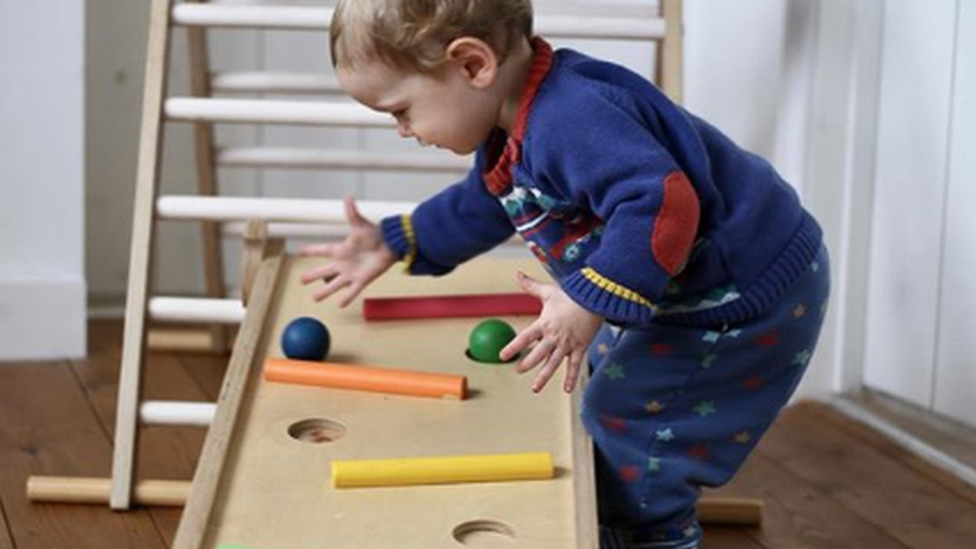 Ребенок играет с деревянными игрушками