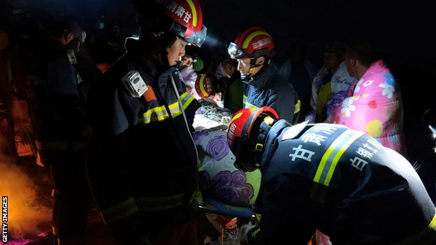 Rescuers search for and attend to survivors