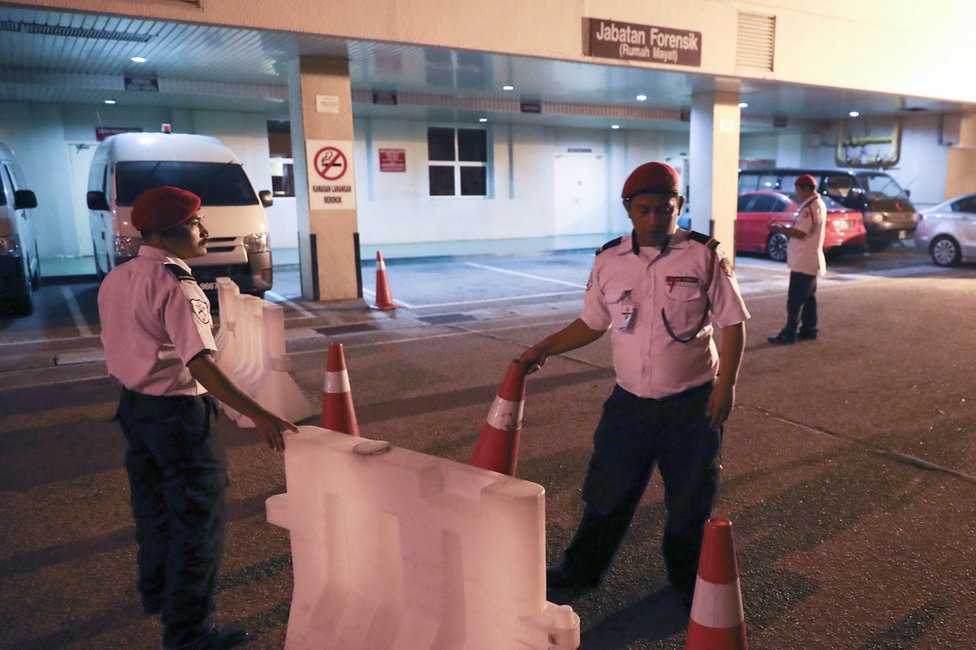 Сотрудники службы безопасности больницы блокируют вход в судебно-медицинское отделение больницы в Путраджайе, Малайзия, 14 февраля