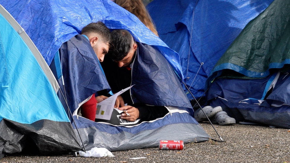 Two men sheltering in a tent