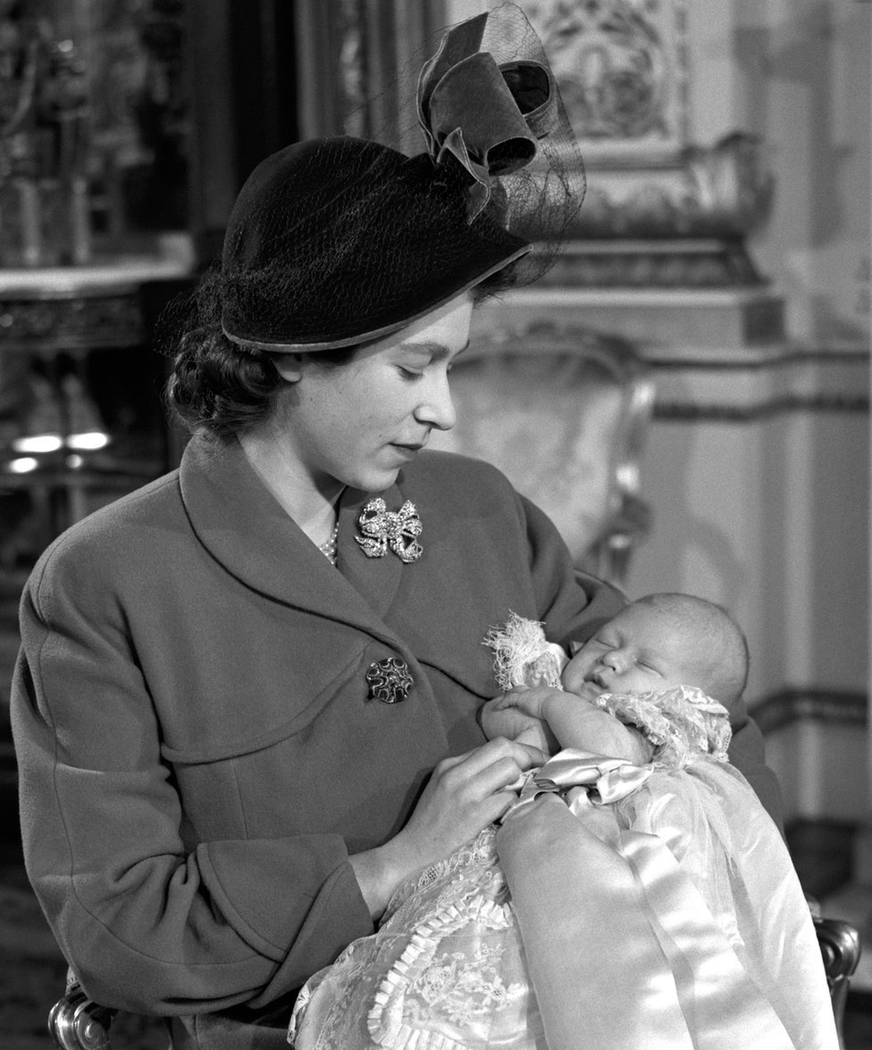 La princesa Isabel sostiene a su hijo, el príncipe Carlos, después de su ceremonia de bautismo en el Palacio de Buckingham, en 1948.