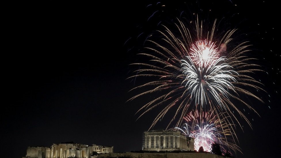 Kembang api menerangi langit di atas kuil Parthenon di puncak bukit Acropolis selama perayaan Tahun Baru di Athena Yunani, 01 Januari 2023.