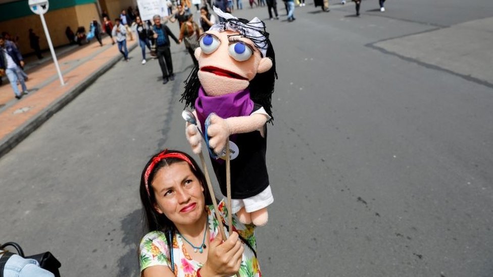 Женщина держит марионетку во время акции протеста, поскольку национальная забастовка продолжается в Боготе, Колумбия, 27 ноября 2019 г.