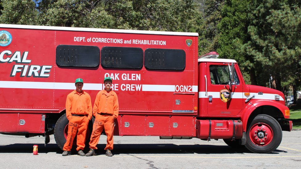 Заключенные стоят перед пожарной машиной