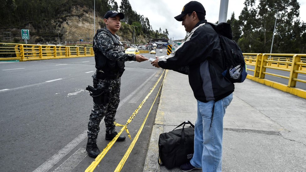 Un migrante venezolano muestra sus papeles en la frontera con Ecuador