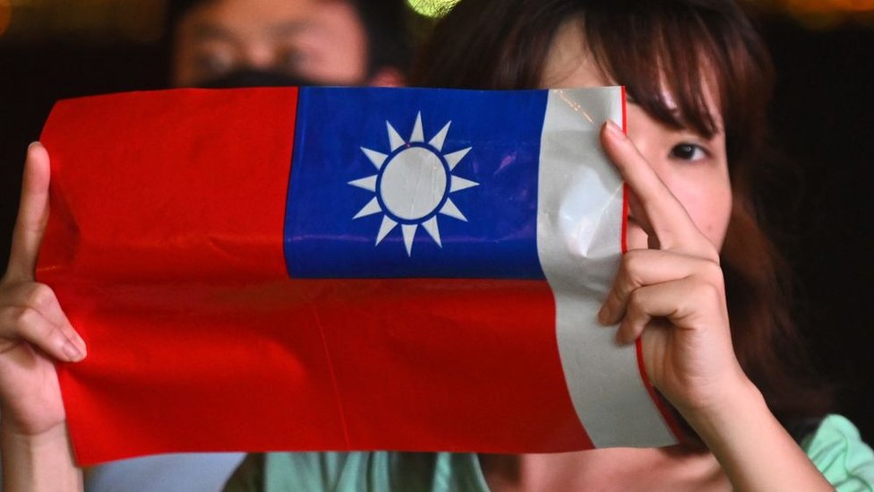 Una mujer sostiene una bandera taiwanesa