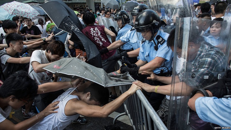 Столкновения протестующих с ОМОНом возле правительственного комплекса Гонконга 27 сентября 2014 года в Гонконге.
